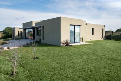 fachada moderna con grandes ventanales en entorno rural — proyecto Costa Esmeralda 3, por Arquitecto Caceres, en Costa Esmeralda