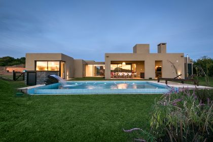 Casa moderna con piscina y patio de césped — proyecto Costa Esmeralda 3, por Arquitecto Caceres, en Costa Esmeralda