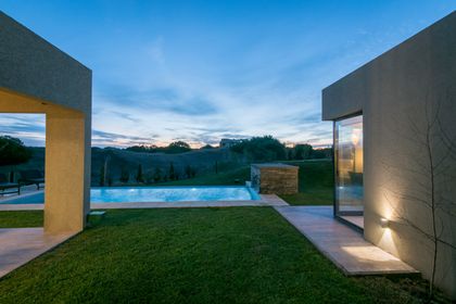 piscina moderna minimalista al atardecer con luces cálidas — proyecto Costa Esmeralda 3, por Arquitecto Caceres, en Costa Esmeralda