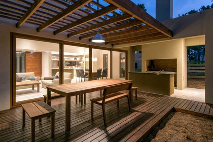 Quincho moderno con deck de madera y pérgola — proyecto Costa Esmeralda Casa MAI Lote 374 Deportiva, por Arquitecto Caceres, en Costa Esmeralda