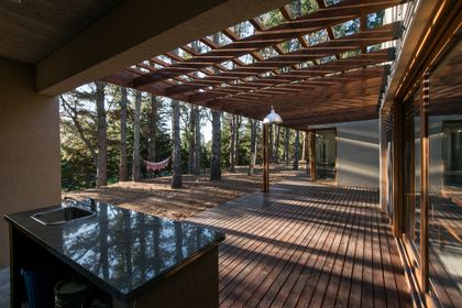 Patio moderno con pérgola de madera y vista al bosque — proyecto Costa Esmeralda Casa MAI Lote 374 Deportiva, por Arquitecto Caceres, en Costa Esmeralda