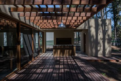 Patio de madera con pérgola y parrilla integrada — proyecto Costa Esmeralda Casa MAI Lote 374 Deportiva, por Arquitecto Caceres, en Costa Esmeralda
