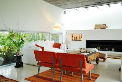 Living moderno y luminoso con sofá y sillones color bordó — proyecto Casa Blanca, por Barrionuevo Arquitects