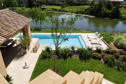 Impresionante piscina moderna rodeada de vegetación y terraza de madera — proyecto Al agua, por Ricardo Pereyra Iraola , en Nordelta