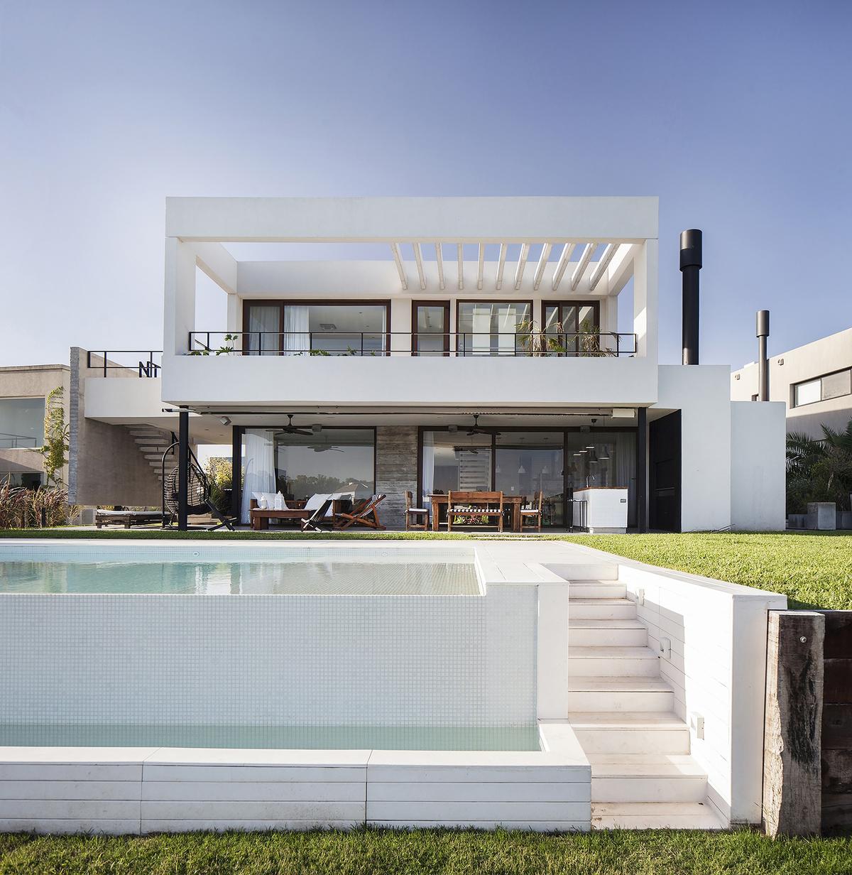Casa moderna com piscina infinita e pergolado branco — projeto Casa Graffiti, por Estudio PK