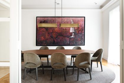 Comedor moderno con mesa ovalada madera y sillas tapizadas grises — proyecto Libertador y Salguero, por Estudio Magrane, en CABA