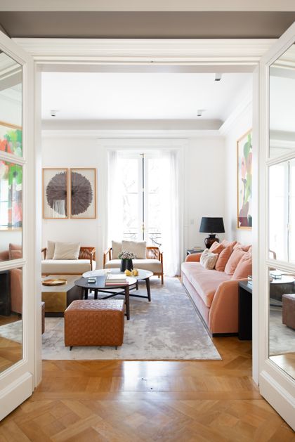 Living moderno con sofa rosa viejo, piso de madera y ventanales amplios — proyecto Libertador y Salguero, por Estudio Magrane, en CABA