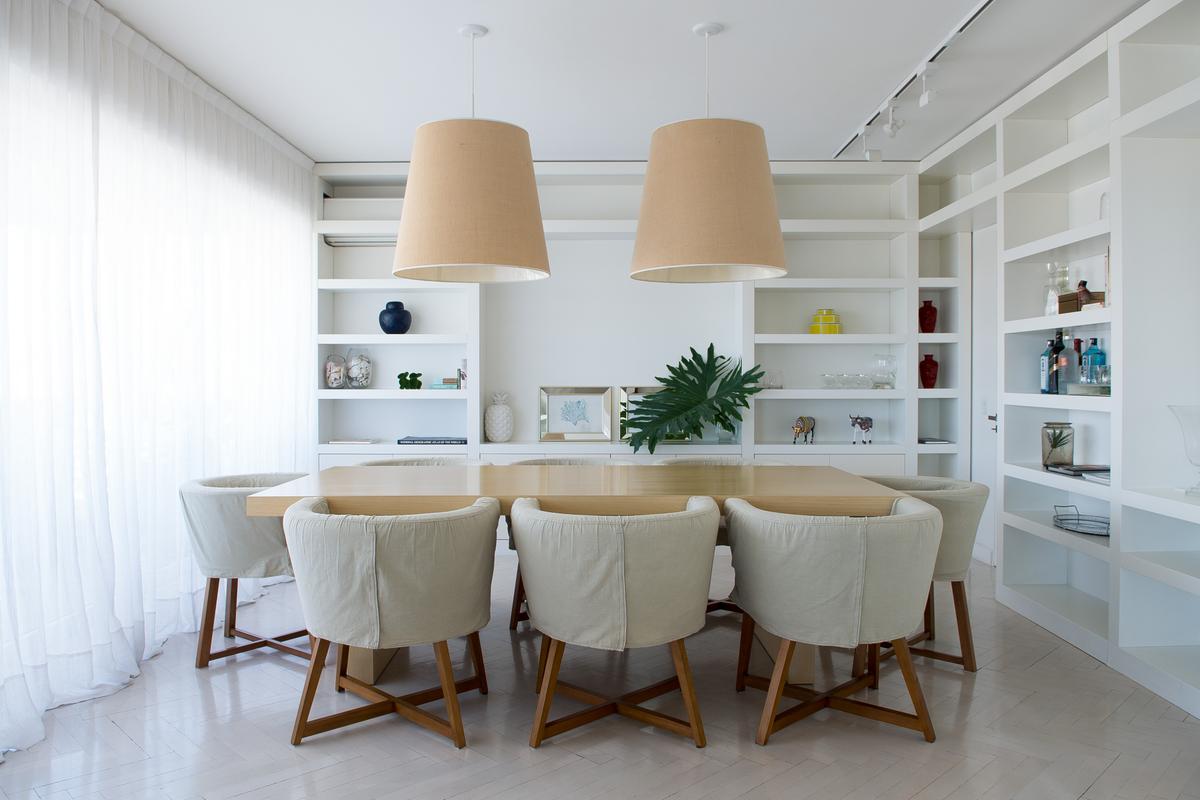 Sala de jantar iluminada com mesa de madeira clara e cadeiras estofadas bege — projeto San Martín de Tours, por Estudio Magrane, em CABA
