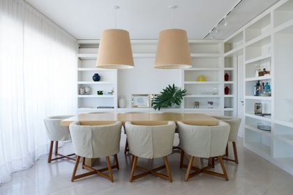 Comedor luminoso con mesa de madera clara y sillas tapizadas beige — proyecto San Martín de Tours, por Estudio Magrane, en CABA