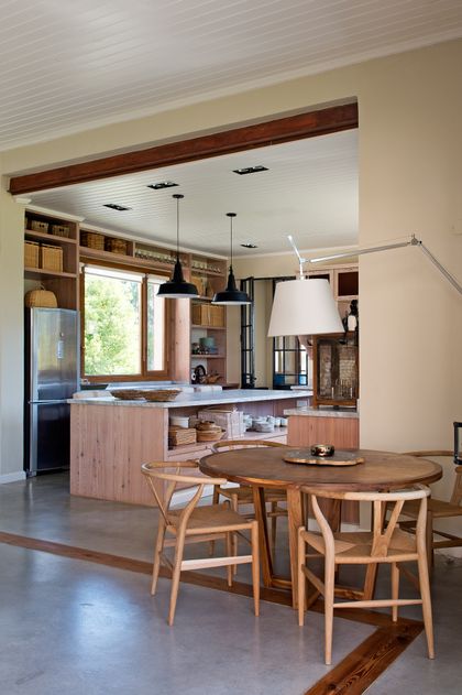 Cocina rústica con isla central de madera y comedor integrado — proyecto Santa María de Lobos, por Estudio Magrane, en Lobos