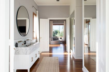 Baño moderno con mesada de mármol y ventanal amplio — proyecto Santa María de Lobos, por Estudio Magrane, en Lobos
