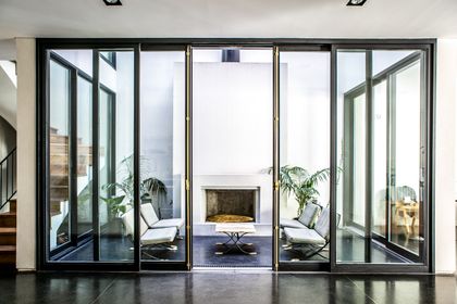 Living moderno con grandes ventanales corredizos y hogar — proyecto Belgrano, por Estudio Magrane, en Belgrano