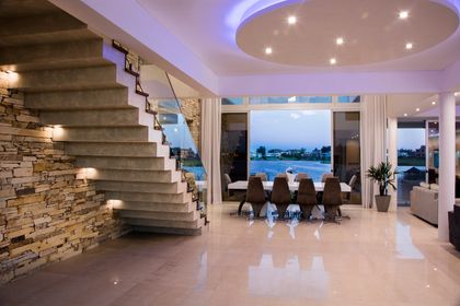 Comedor moderno con escalera flotante y vista costera — proyecto La Reserva Cardales I, por ARQCONS, en Los Cardales