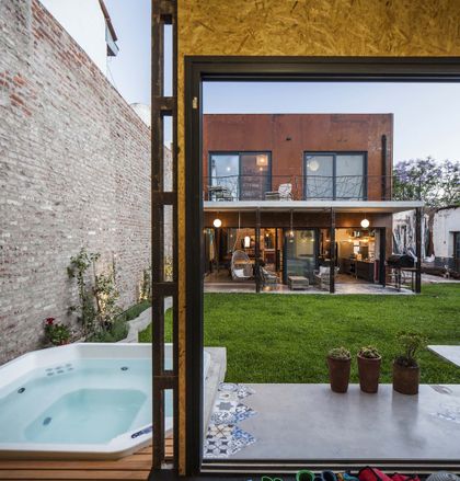 Pileta blanca junto a pared de ladrillos y moderna fachada — proyecto Casa Lavalle, por Silvia Soqueff, en CABA