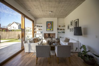 Living moderno con techo de hormigón y grandes ventanales — proyecto LS 624, por Grupo Pauta Arquitectura
