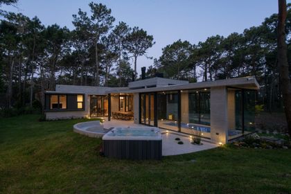 Casa moderna rodeada de bosque con piscina y ventanales — proyecto Casa G y G, por TAVA Coop, en Cariló