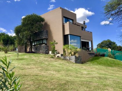 fachada moderna con ventanales amplios y entorno natural — proyecto La Serena, por Blussand Tosco, en Córdoba