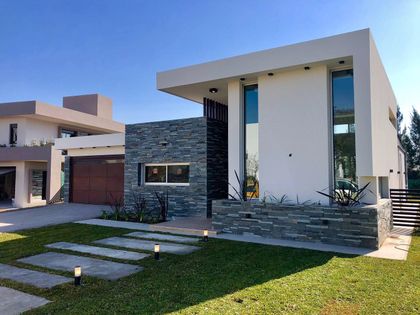 fachada moderna con volúmenes geométricos y detalles en piedra y madera — proyecto Manantiales Z, por Blussand Tosco, en Córdoba