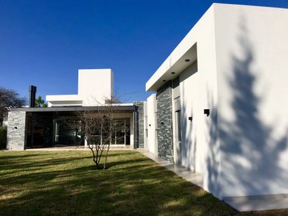 fachada moderna blanca con detalles en piedra — proyecto Manantiales Z, por Blussand Tosco, en Córdoba