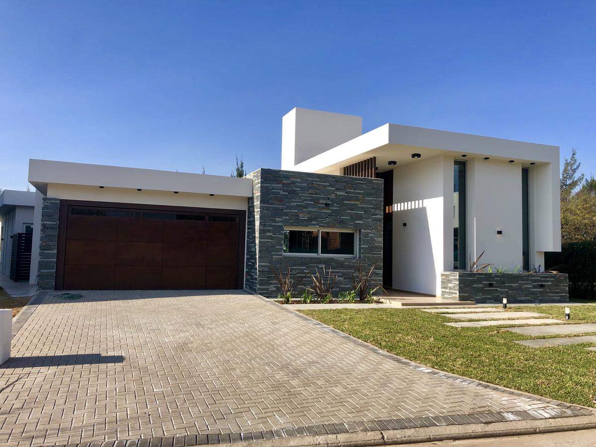 Fachada moderna de casa suburbana com contraste de materiais — projeto Manantiales Z, por Blussand Tosco, em Córdoba