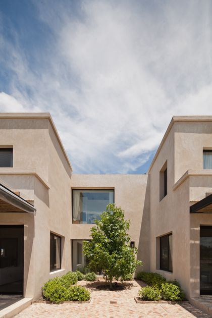 Patio interior moderno con plantas entre construcciones minimalistas — proyecto La Tahona, por BAS Y GARCIA , en Canelones Departamento de Canelones