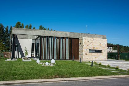 Casa contemporánea minimalista con fachada de hormigón y piedra — proyecto CASA SI, por DX ARQ