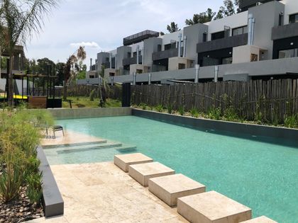 Pileta turquesa con deck y edificios contemporáneos de fondo — proyecto SOTAVENTO, por DX ARQ