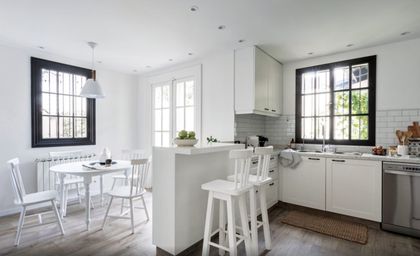 Cocina blanca moderna con isla, grandes ventanales y comedor integrado — proyecto Olivos, por Biaus Pieres Arquitectura