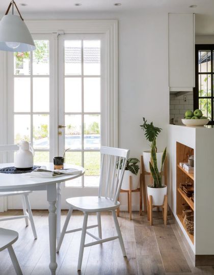 Comedor luminoso con mesa redonda blanca y puertas vidriadas hacia jardín — proyecto Olivos, por Biaus Pieres Arquitectura