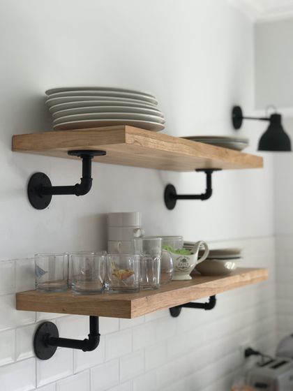 Estantes flotantes de madera con herrajes industriales negros en cocina — proyecto Peña, por Biaus Pieres Arquitectura, en Recoleta