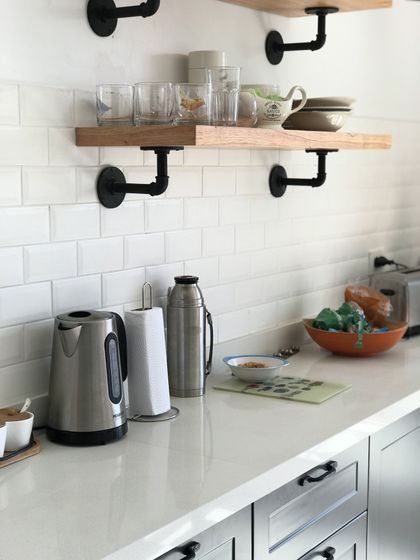 Cocina moderna con estantes flotantes de madera y soportes industriales negros — proyecto Peña, por Biaus Pieres Arquitectura, en Recoleta