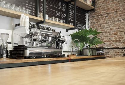 Barra de café con máquina espresso, ladrillo visto y planta verde decorativa — proyecto Estilo Barista, por Estudio Simbiosis