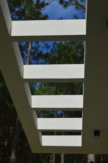 Pérgola moderna de hormigón con aberturas lineales — proyecto PINAMAR NORTE, por LADAGA-RUARTE-Pinamar, en Pinamar