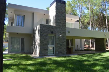 Fachada moderna de casa residencial rodeada de vegetación — proyecto PINAMAR NORTE, por LADAGA-RUARTE-Pinamar, en Pinamar