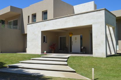 fachada moderna con volúmenes de hormigón y jardines — proyecto LA HERRADURA - Boulevard III, por LADAGA-RUARTE-Pinamar, en Pinamar