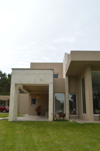 fachada moderna con jardín y piscina de hormigón visto — proyecto LA HERRADURA - Boulevard III, por LADAGA-RUARTE-Pinamar, en Pinamar