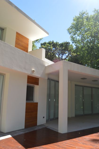 fachada moderna con deck de madera y amplios ventanales — proyecto CARILO - Boyero, por LADAGA-RUARTE-Pinamar, en Cariló