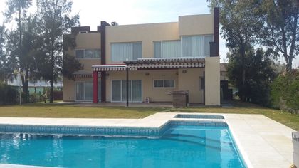 Casa moderna con pileta y jardín en zona suburbana — proyecto Terralagos 1, por Arquitecto Oscar Sanguineti, en Canning