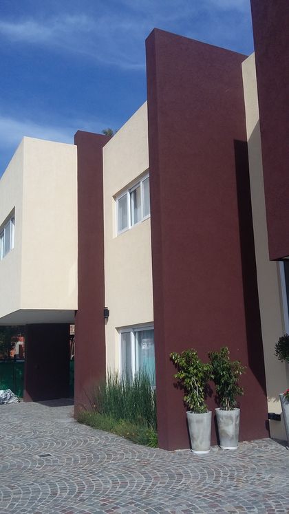 Fachada moderna con volúmenes geométricos y colores contrastantes — proyecto Terralagos 1, por Arquitecto Oscar Sanguineti, en Canning