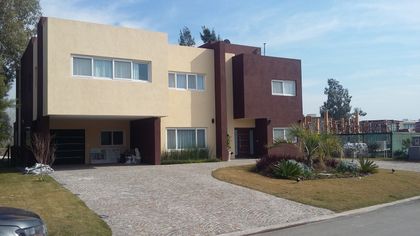 fachada moderna con grandes ventanales y contraste de color — proyecto Terralagos 1, por Arquitecto Oscar Sanguineti, en Canning