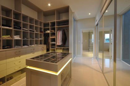 Amplio vestidor moderno con isla central y estanterías integradas — proyecto OP House, por A+R Arquitectos