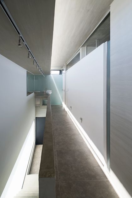 Pasillo minimalista con luz natural y paredes blancas — proyecto Casa BLQ, por Luciano Kruk