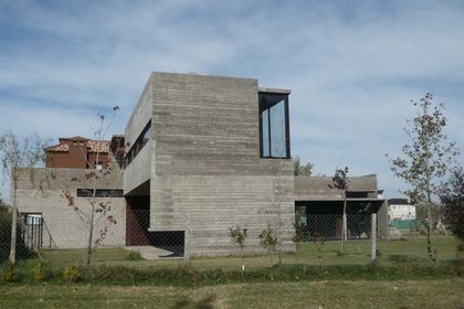 Casa contemporánea con fachada hormigón visto, obra en construcción avanzada — proyecto Casa Canning, por Luciano Kruk, en Canning