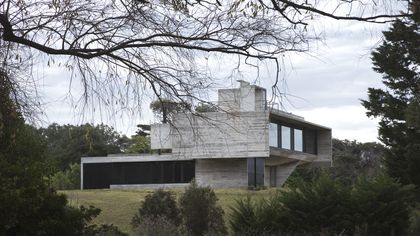 Casa contemporánea de hormigón y vidrio en paisaje verde arbolado — proyecto Casa Cariló, por Luciano Kruk, en Cariló