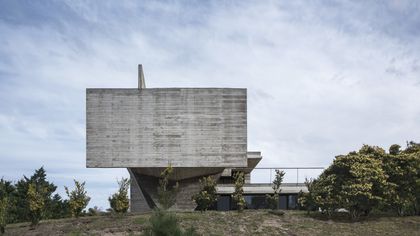 Casa contenedor de hormigón con voladizo suspendido y escalera exterior — proyecto Casa Cariló, por Luciano Kruk, en Cariló