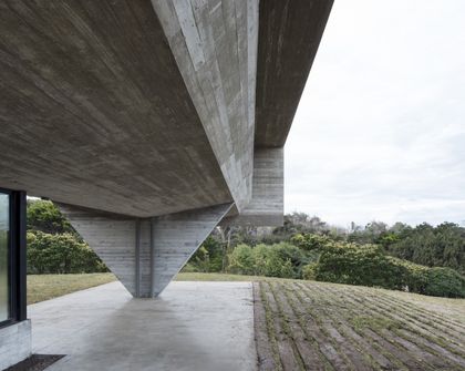 Terraza bajo estructura hormigón con vistas al campo y vegetación — proyecto Casa Cariló, por Luciano Kruk, en Cariló