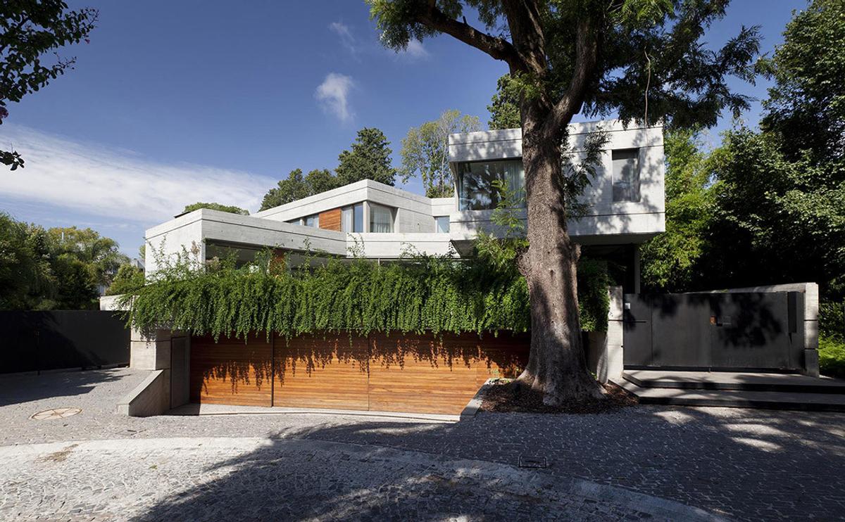 Fachada moderna com concreto, madeira e grandes janelas — projeto Acasusso, por Remy Arquitectos, em Acassuso