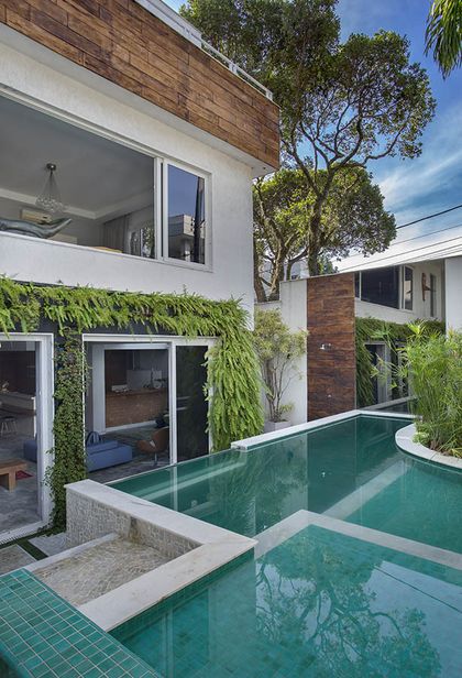 Casa moderna con pileta verde, jardines verticales y conexión interior-exterior — proyecto Casa Jardim Guanabara, por Amanda Miranda