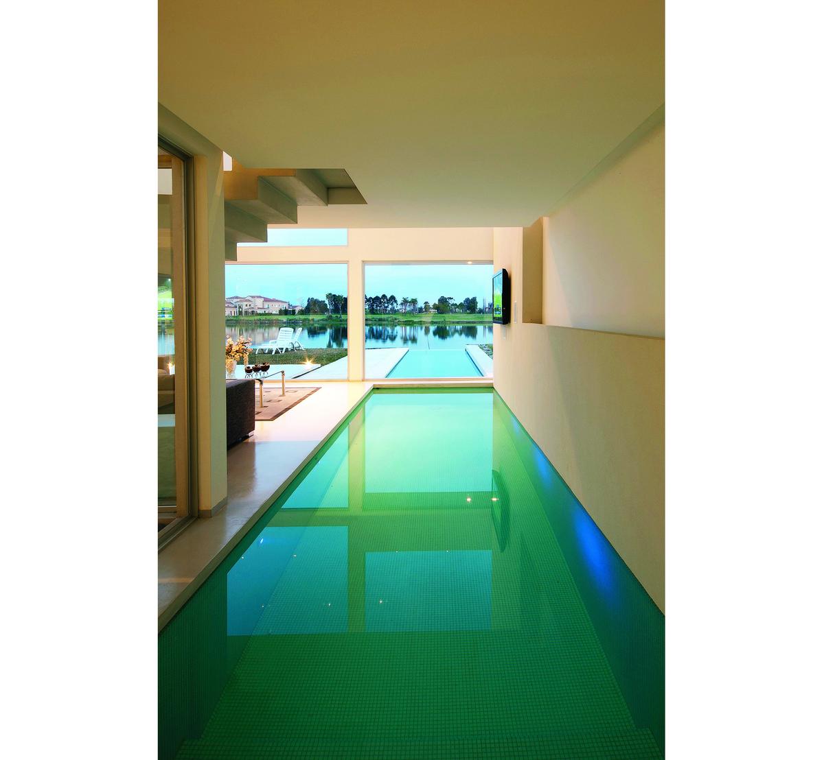 Área de piscina interna moderna com janelas do chão ao teto — projeto Casa Pool, por Vanguarda Arquitectos, em Nordelta