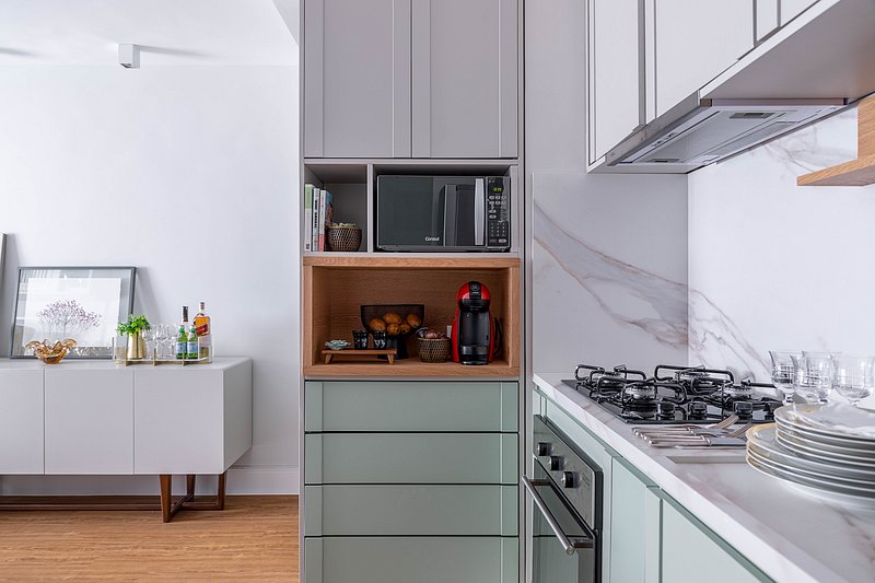 Apto flat de 58 m² tem área social integrada, marcenaria colorida na cozinha e soluções arquitetônicas